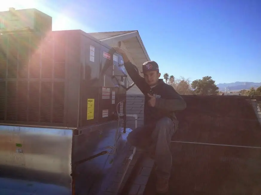 HVAC technician performing Air Duct Cleaning on a rooftop unit in Park Hills